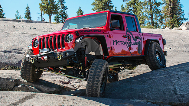 red Jeep JT Gladiator with MetalCloak decals and black body armor tow winch and with undercloak skidplate system and fenders on sloped granite slab trail in the Rubicon trail