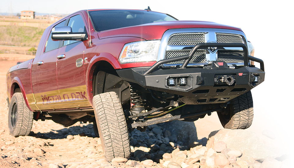 Red Dodge Ram with suspension on rocks