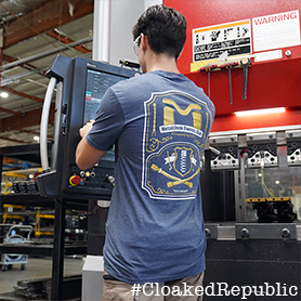A Man Working With A Navy Tee That Has The MetalCloak Owners Club Crest on the Back